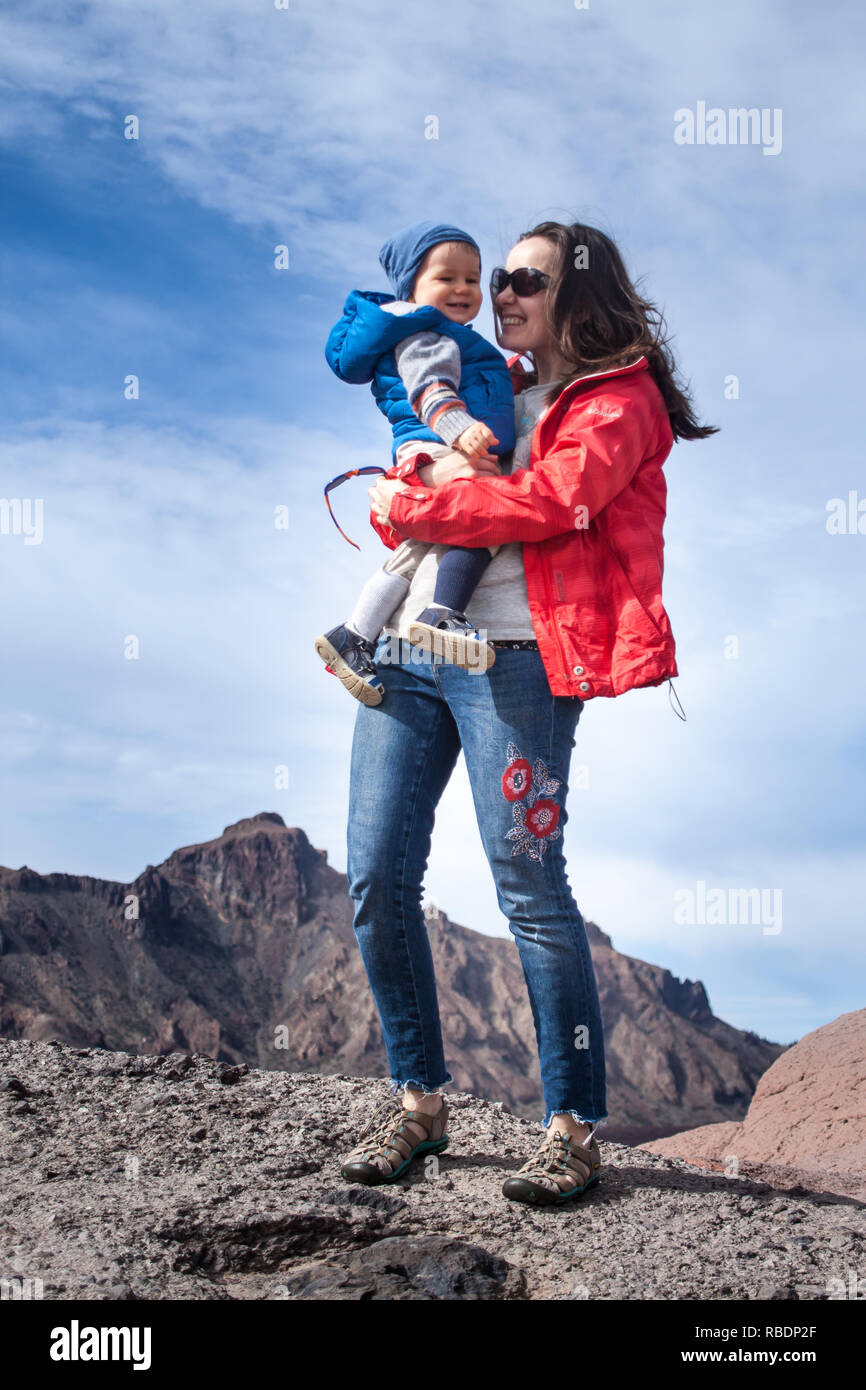 Une belle photo d'une belle femme et son fils debout sur une montagne de l'arrière-plan d'un ciel nuageux Banque D'Images