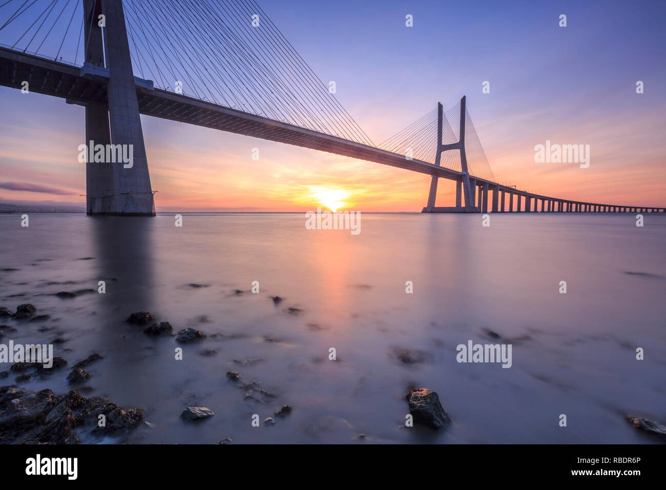 Les couleurs de l'aube sur le pont Vasco de Gama qui enjambe le Tage dans la région de Parque das NaÃ§Ãµes l'Europe Portugal Lisbonne Banque D'Images