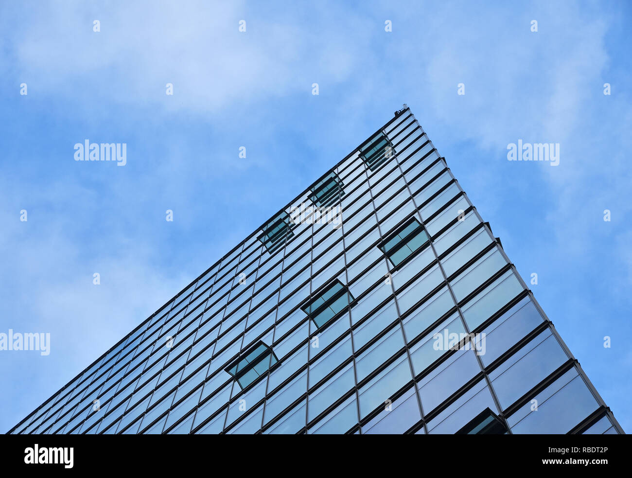 La texture de fond d'affaires moderne verre de construction de gratte-ciel avec motif windows plus de réflexion cloudy blue sky, low angle view Banque D'Images