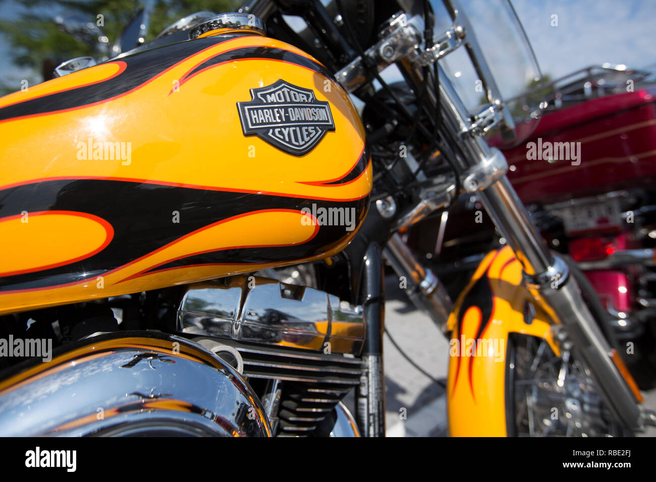 Un gros plan d'un réservoir de gaz avec Harley-Davidson jaune et noir peint rouge feu et un logo Harley-Davison classique Banque D'Images