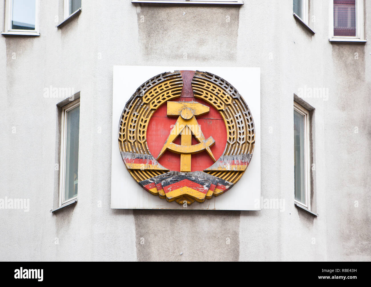 L'emblème de l'ancienne République démocratique allemande avec les symboles communistes de la faucille et du marteau et de pointes autour. Banque D'Images