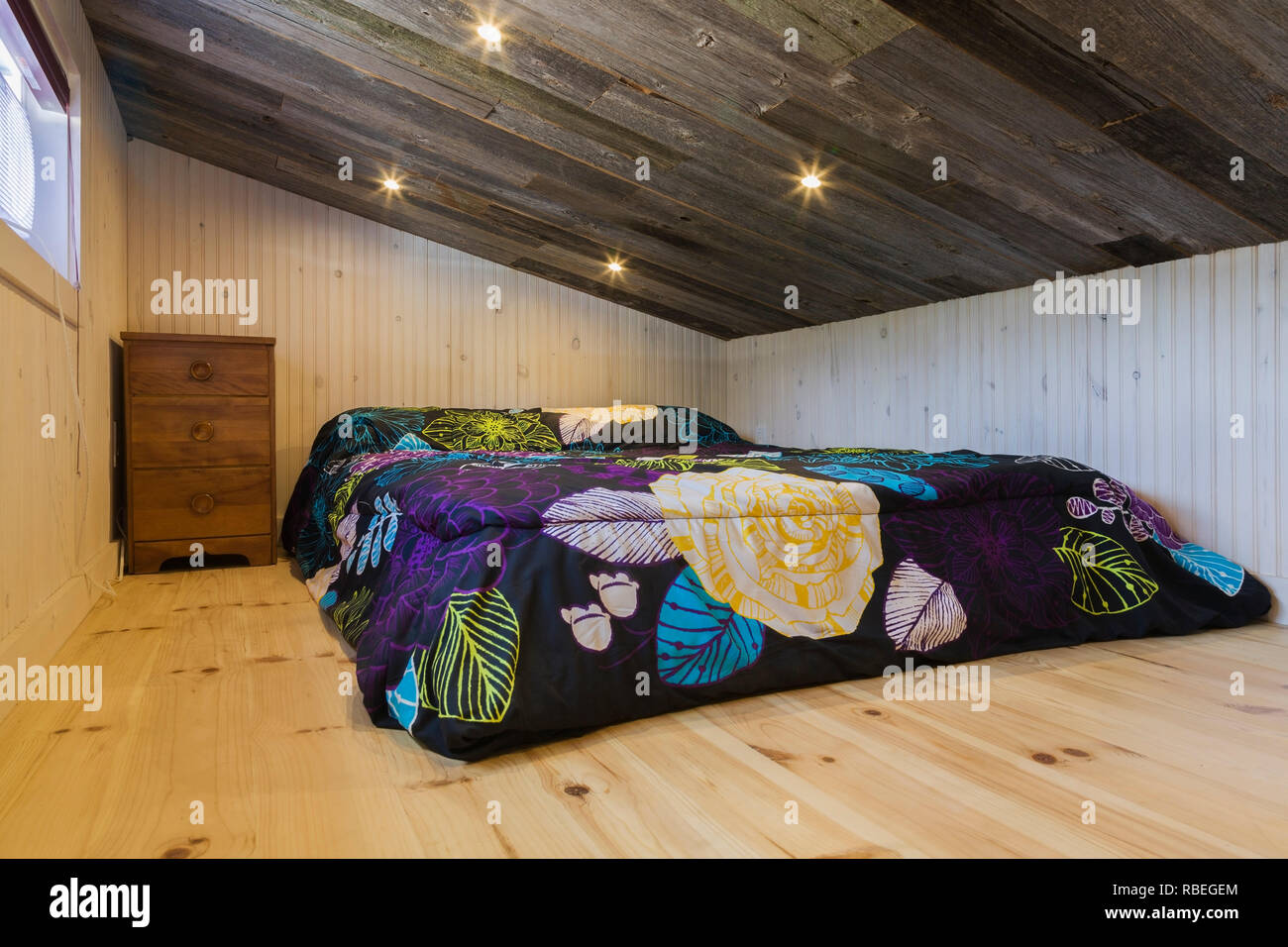 A l'étage chambre avec lit queen size sur plancher en pin et bois grange  rustique ancien plafond en pente à l'intérieur de 24 pieds x 8 contemporain  mini mobile house Photo Stock -