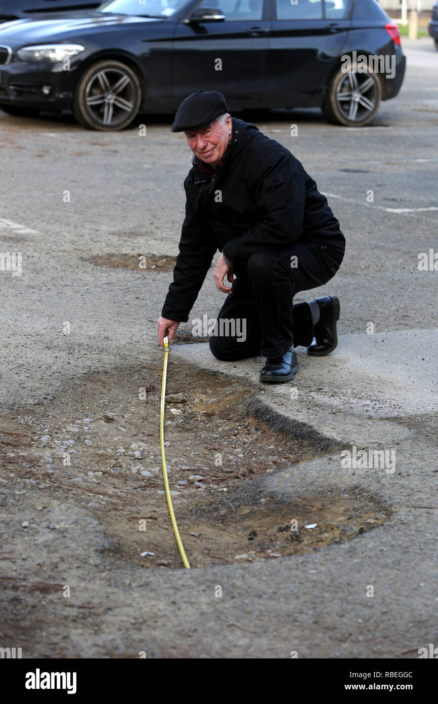 La mesure de l'homme grand pot-trous dans un parking public à Bognor Regis, West Sussex, UK. Banque D'Images