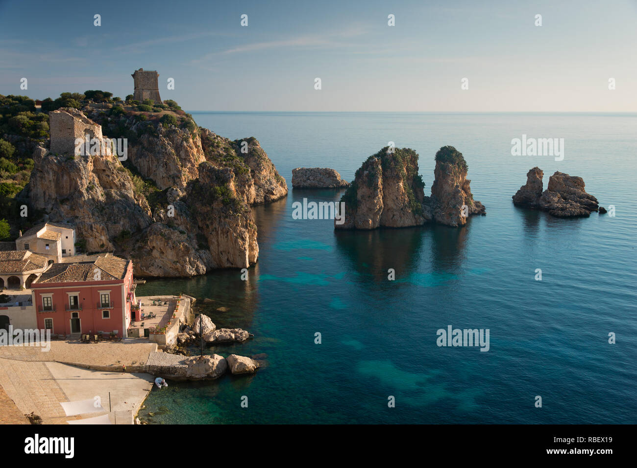 Les Faraglioni dans la mer Méditerranée et la Tonnara de Scopello dans la ville, au pied de Lo Zingaro NP en Sicile, Italie. Banque D'Images