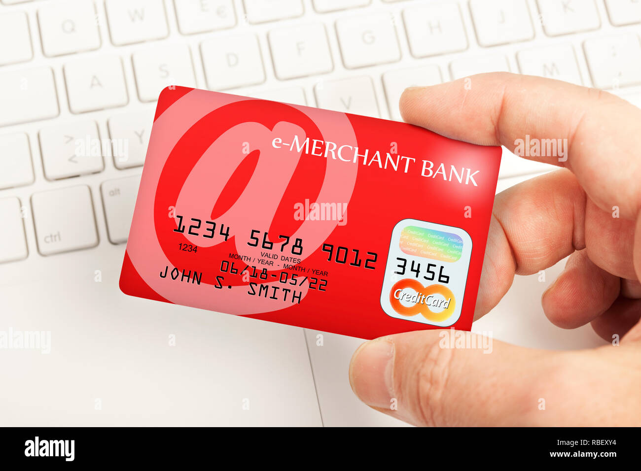 Paiement par carte de crédit en ligne - main tenant une carte de crédit  au-dessus d'un clavier. Dessin de fantaisie et nom de la banque Photo Stock  - Alamy