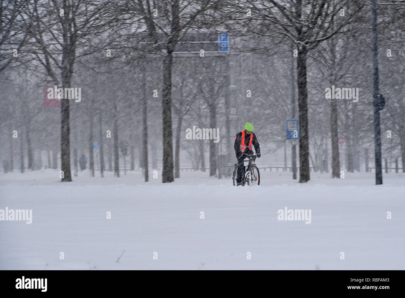 Munich Riem, Deutschland. 10 janvier, 2019. Le chaos de la neige sur les rues de Bavière - probablement celle qui arrive à son lieu de travail en vélo, comme ce cycliste avec gilet signal de conduire sur la neige, neige-couvertes piste cyclable. Neige continue sur 10.01.2019, fournir pour la neige le chaos, le chaos de la circulation, d'hiver en Bavière. Utilisation dans le monde entier | Credit : dpa/Alamy Live News/Alamy Live News Banque D'Images