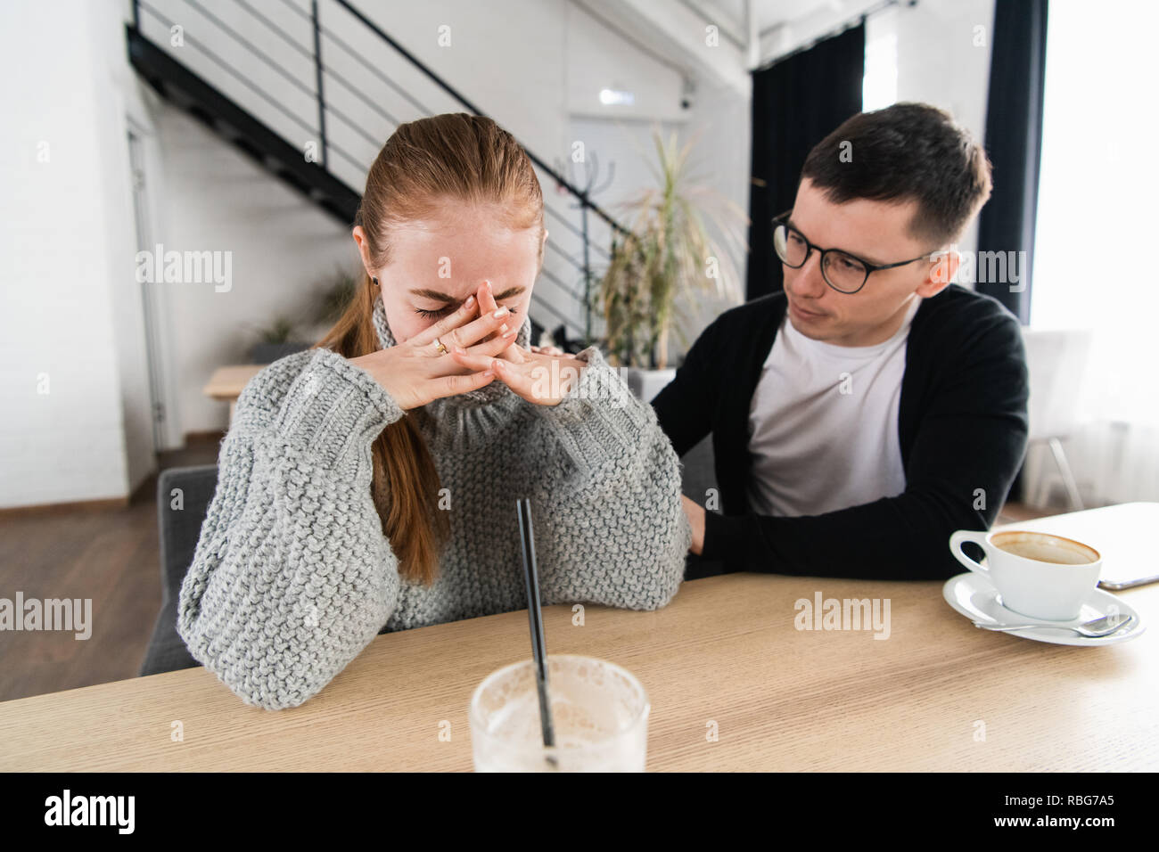 Réunion d'une femme triste et un ami ou petit ami essaie de réconforter dans le café Banque D'Images