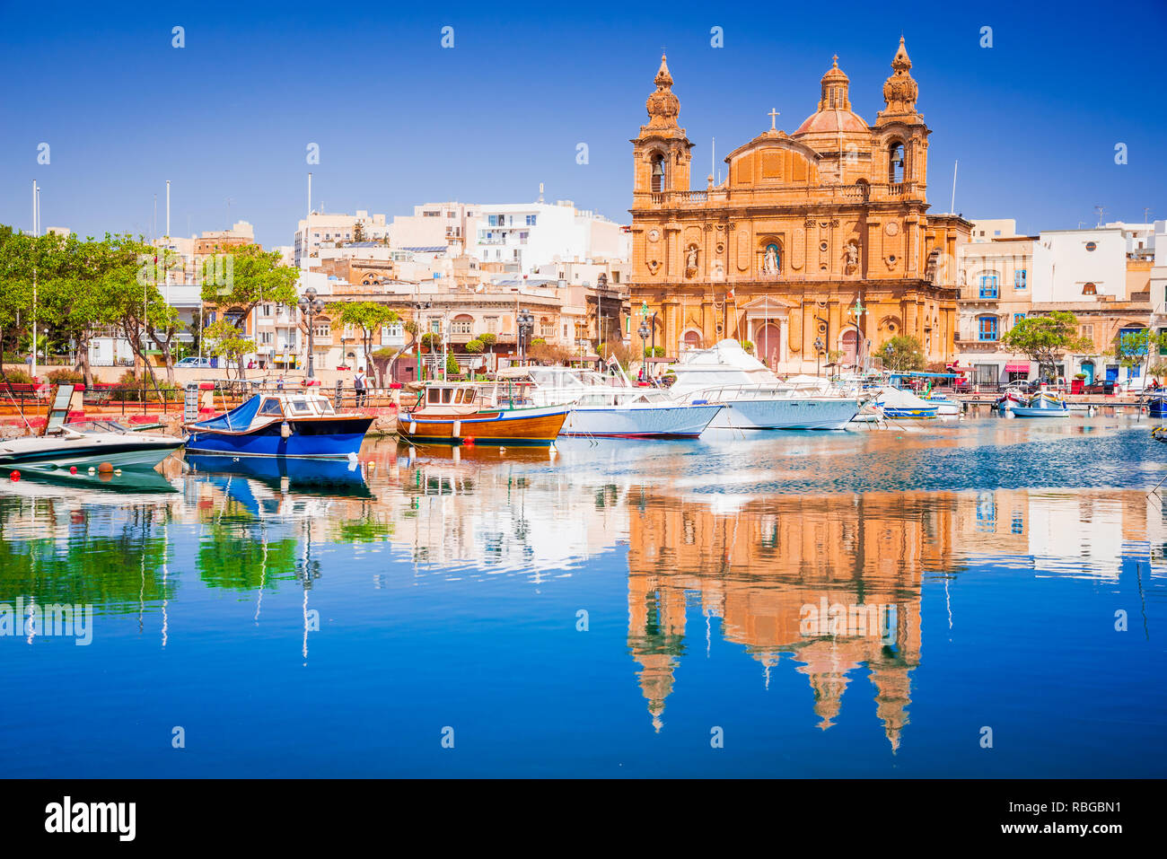 La Valette, Malte. Msida Marina Boat et église la réflexion dans l'eau. Banque D'Images