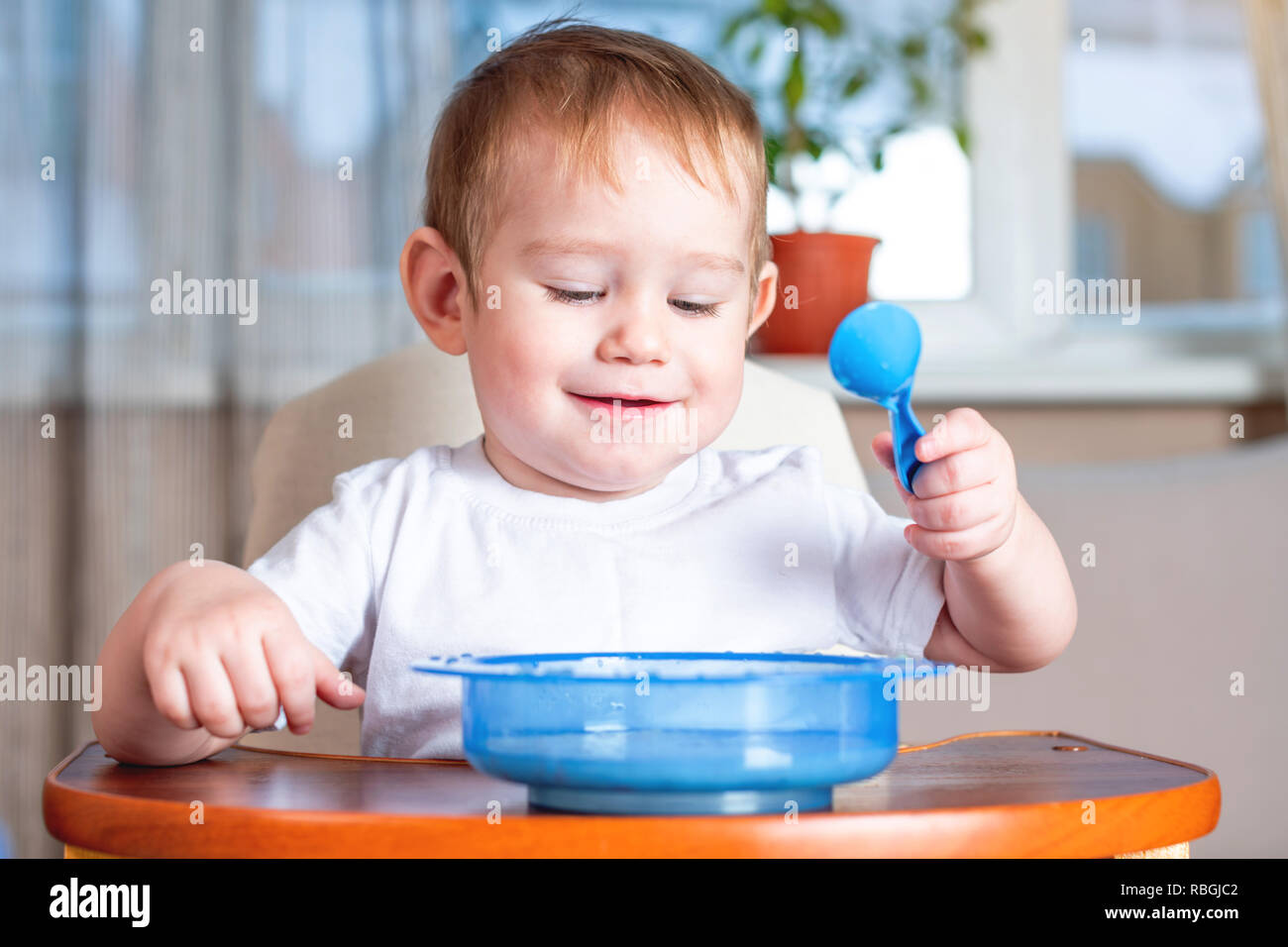 Petit bébé garçon d'apprendre à manger avec une cuillère lui-même à la  table des enfants dans la cuisine. Le concept de la saine alimentation pour  bébés Photo Stock - Alamy