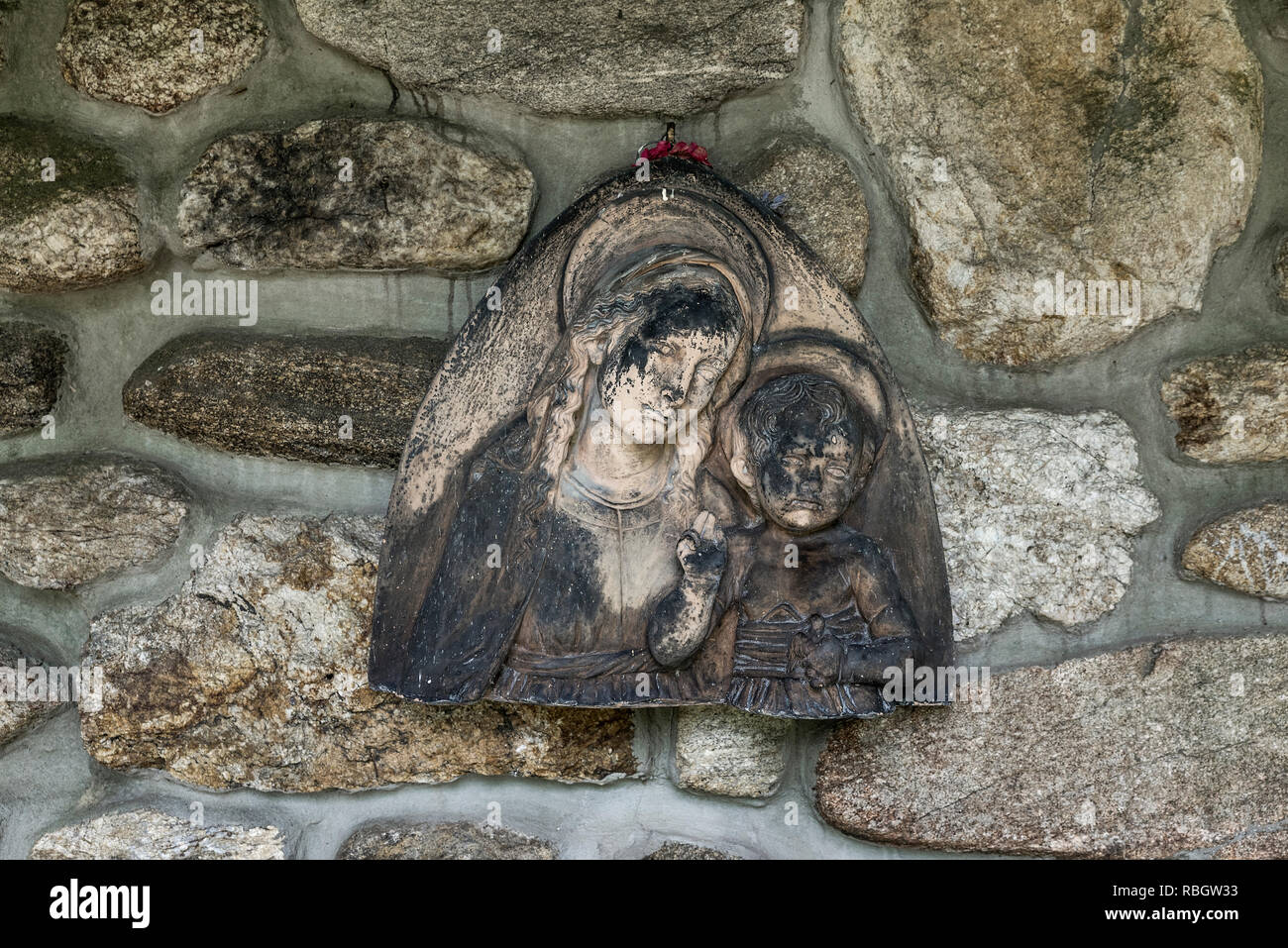 Vierge à l'enfant contre le mur en pierre de taille d'une église monastique, St Joesph abbaye trappiste, Spencer, Massachusetts, USA. Banque D'Images