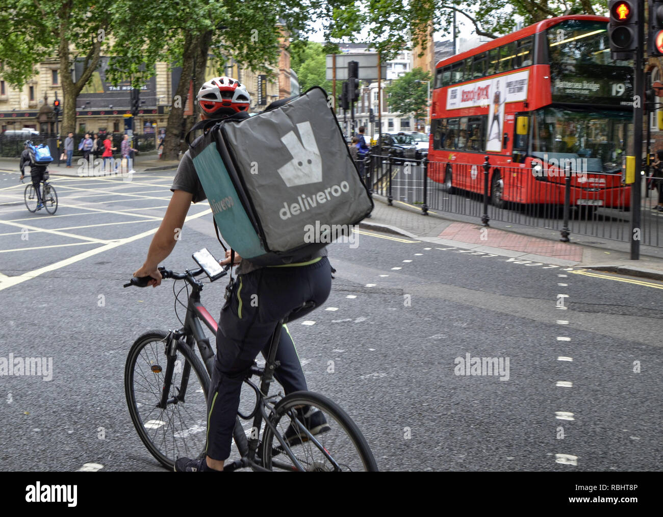 Londres, Royaume-Uni, juin 2018. Un travailleur d'Deliveroo, une société qui gère des restaurants de livraison à domicile près de chez vous. Le rider jongle par Banque D'Images