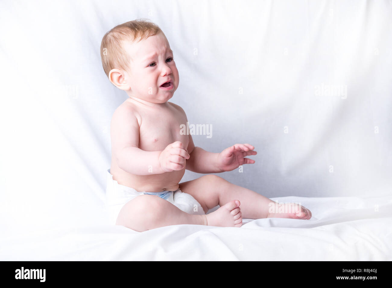 Blue Eyed Mignon Bebe 6 9 Mois Triste Pleurer Fond Blanc Les Emotions De L Enfant La Douleur De La Dentition Photo Stock Alamy