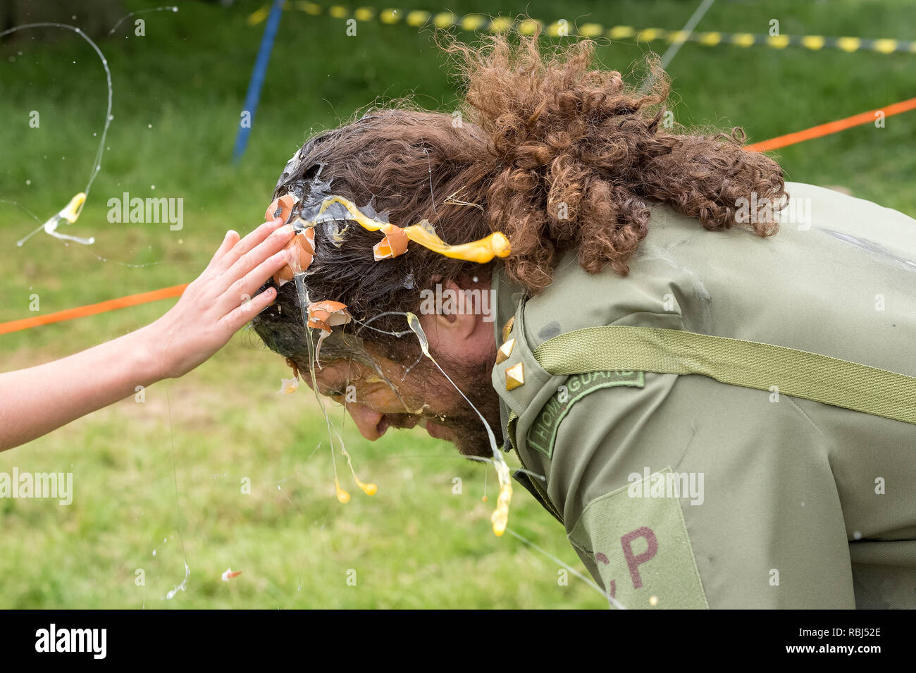 Joel Hicks agissant en tant que cible humaine lors du lancer d'oeufs, Swaton Championnats Kermesse, Lincolnshire, Royaume-Uni Banque D'Images