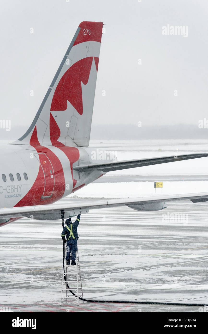 Un Airbus A319 d'être ravitaillé en conditions d'hiver à l'aéroport Jean Lesage de Québec Banque D'Images