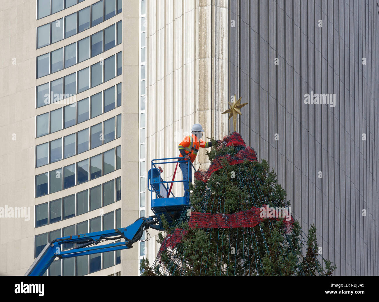 Mettre les travailleurs l'étoile sur l'arbre de Noël au Nathan Phillips Square, Toronto, Canada Banque D'Images