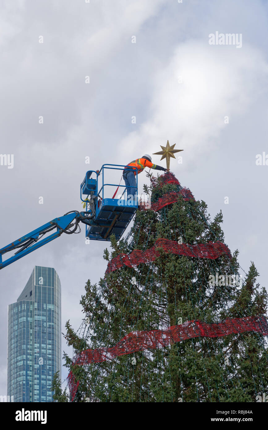 Mettre les travailleurs l'étoile sur l'arbre de Noël au Nathan Phillips Square, Toronto, Canada Banque D'Images