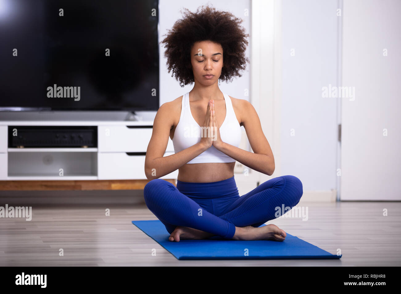 Young African Woman Sitting on Floor dans la position de prière la médiation Banque D'Images