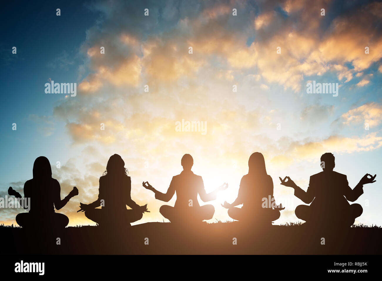 Silhouette de personnes faisant du yoga contre le ciel au petit matin Banque D'Images