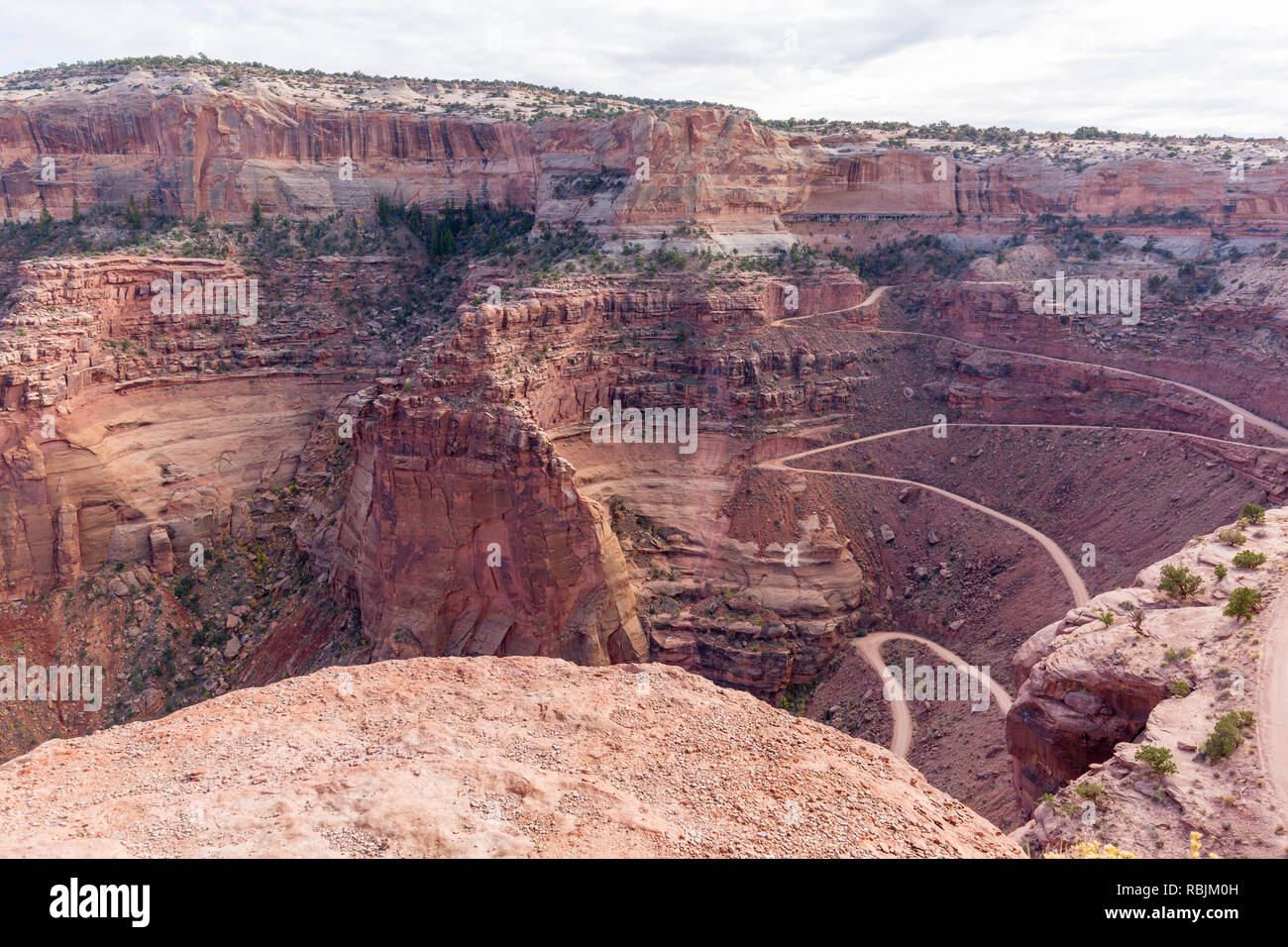 Route sinueuse raide de descendre une vallée dans l'île dans le ciel, domaine de Canyonlands National Park, Utah, USA. Banque D'Images