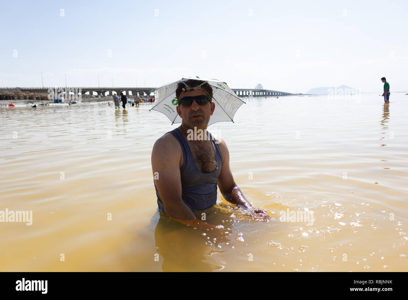 Un homme portant des lunettes de soleil et chapeau parapluie comme dans le lac d'Orumieh, province de l'Ouest, l'Iran Banque D'Images