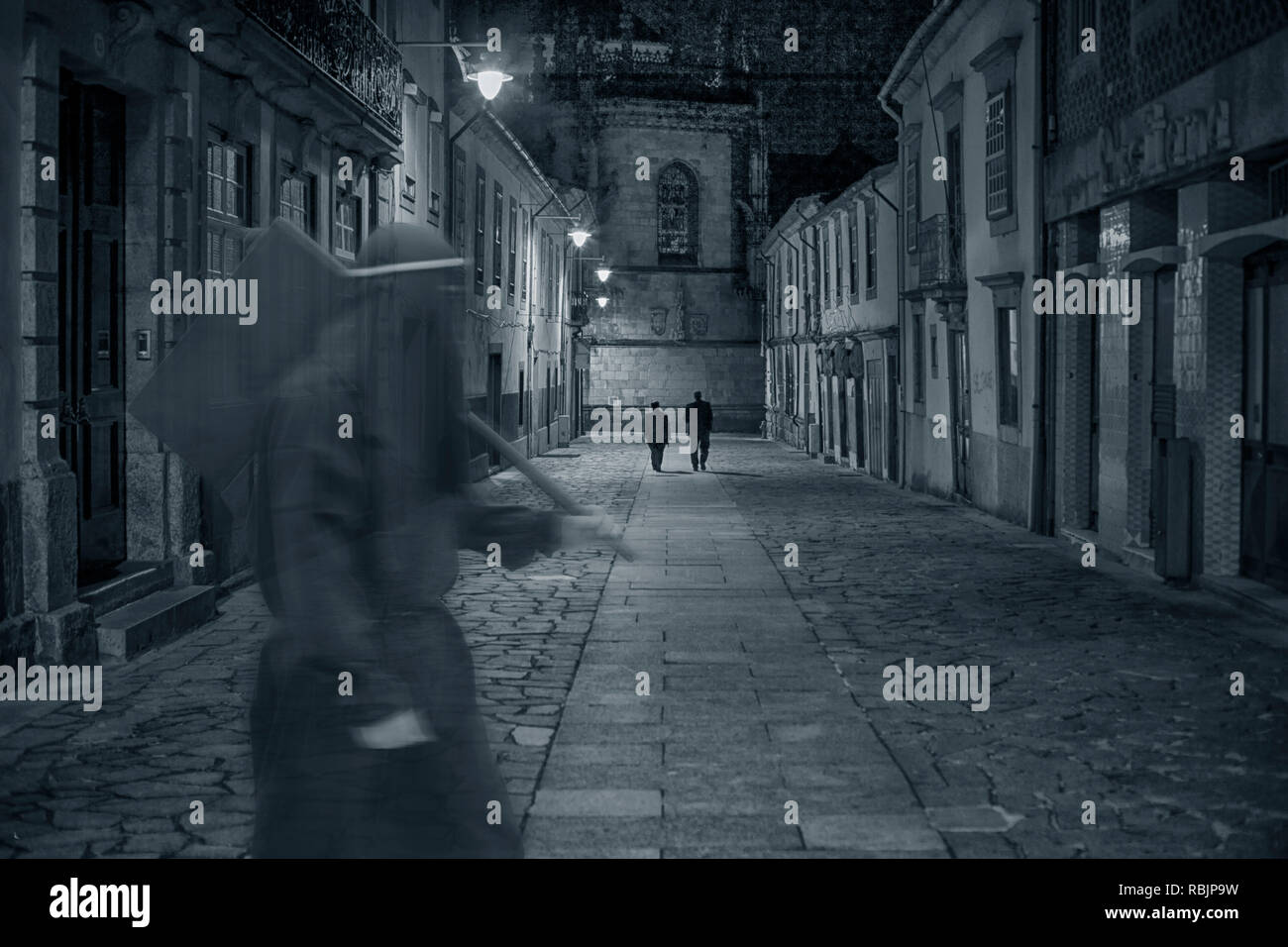 L'ancienne rue de la ville médiévale de nuit avec une mystérieuse figure sinistre en passant par en avant-plan Banque D'Images