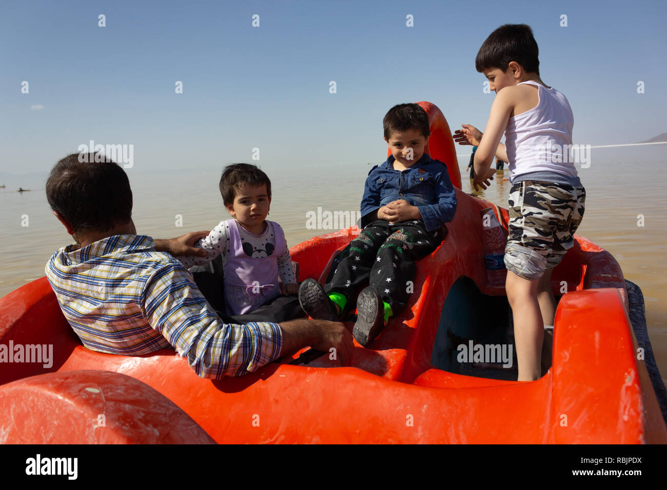 Un homme est monté sur un pédalo avec ses enfants sur le lac d'Orumieh, province de l'Ouest, l'Iran Banque D'Images