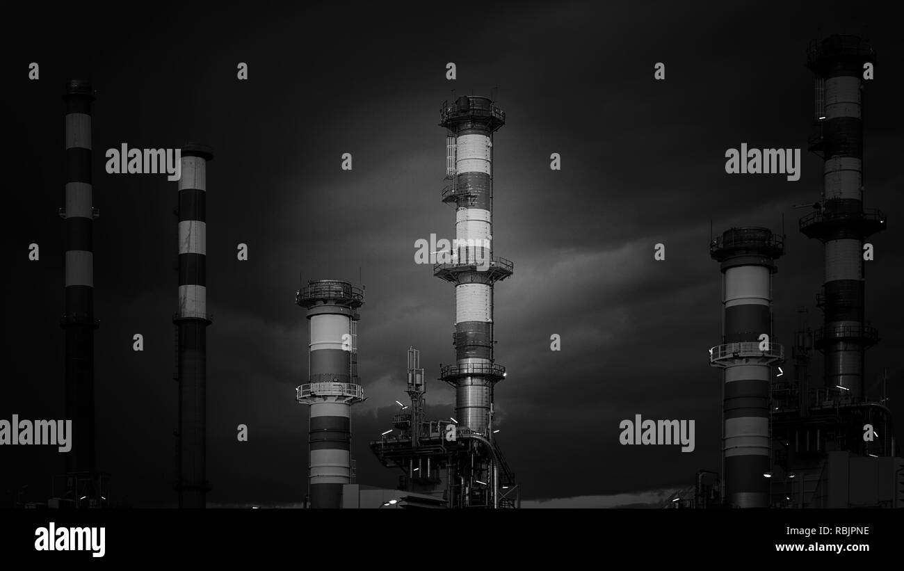 Raffinerie de pétrole au crépuscule. Converti en noir et blanc. Banque D'Images