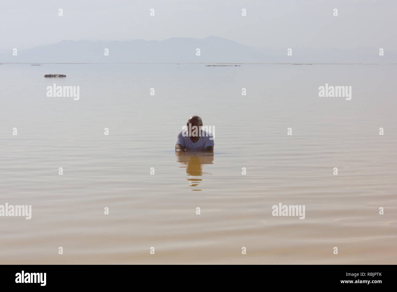 Un vieil homme assis sur salt lake Urmia, province de l'Ouest, l'Iran Banque D'Images