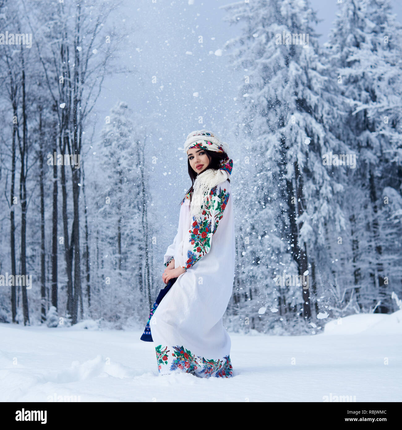 Les jeunes à la mode attrayant dark-haired femme en robe blanche brodée de fleurs, foulard coloré, lin bleu avec sac d'épaule en profonde Banque D'Images