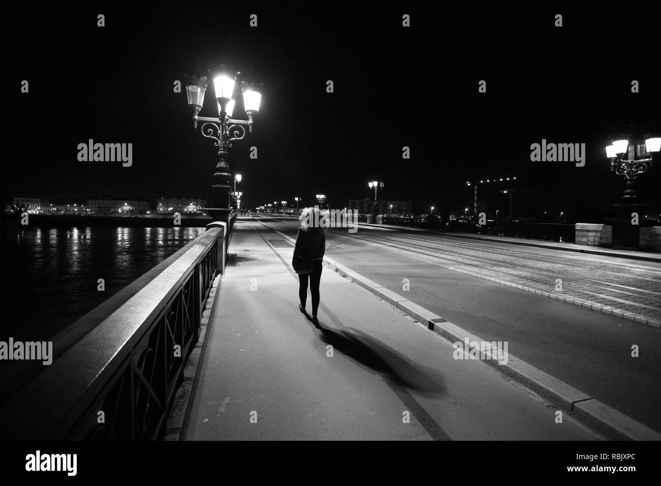 Femme marche sur Pont de Pierre Pont, de nuit, noir et blanc, Bordeaux, France Banque D'Images