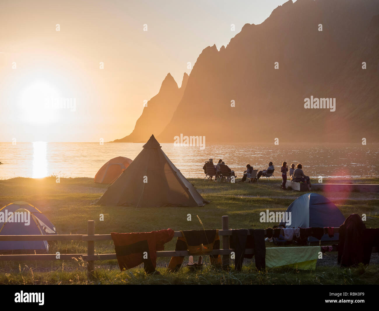 Ersfjordstranden Ersfjord Beach, fjord, les gens assis en petits groupes à la plage, aire de loisirs publics, coucher de soleil, vue montagne gamme Okshornan Banque D'Images