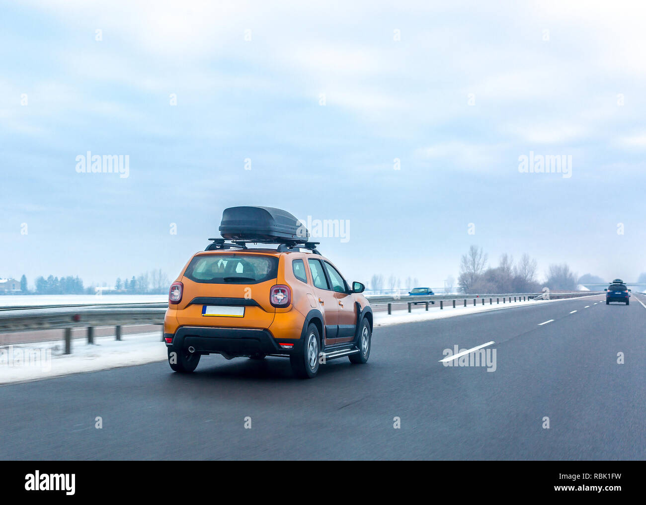 Voiture Orange avec toit assurance fort sur la route en hiver. Voyages en famille concept Banque D'Images