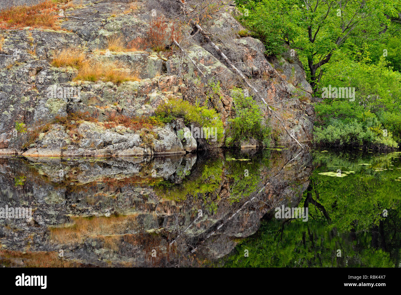 Les affleurements de granit reflétée dans un étang de castors, près de la route du lac Onaping, Ontario, Canada Banque D'Images