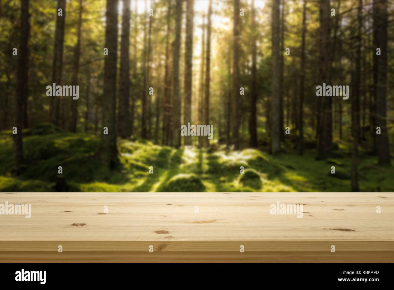 Haut de table en bois en face de la forêt verte blured. Arrière-plan de montage de l'écran du produit. Copie espace design. Banque D'Images