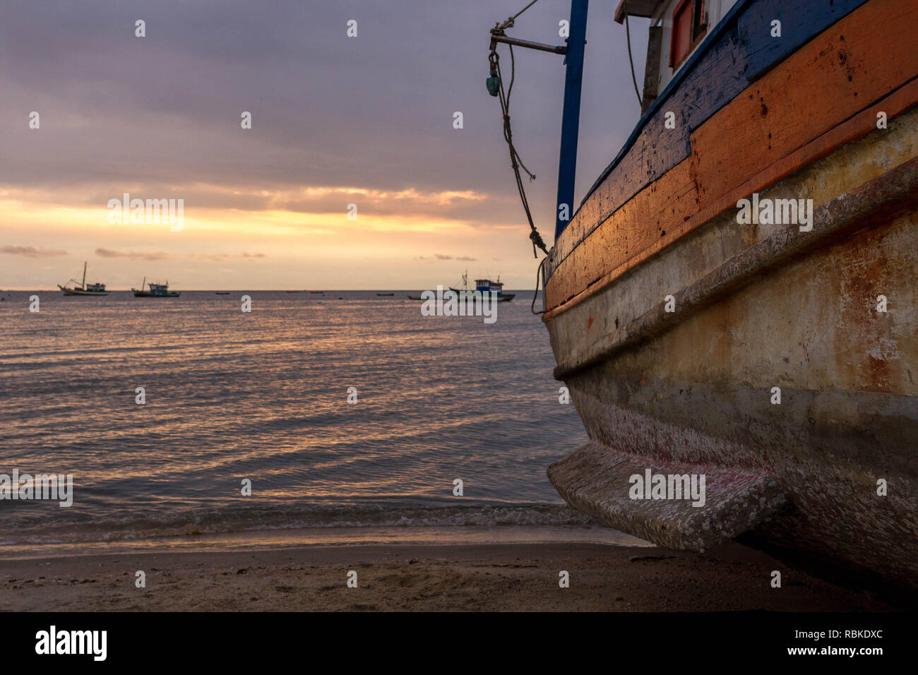 Bateau de pêche en attente d'entretien sur sable avec beau paysage arrière-plan. Banque D'Images