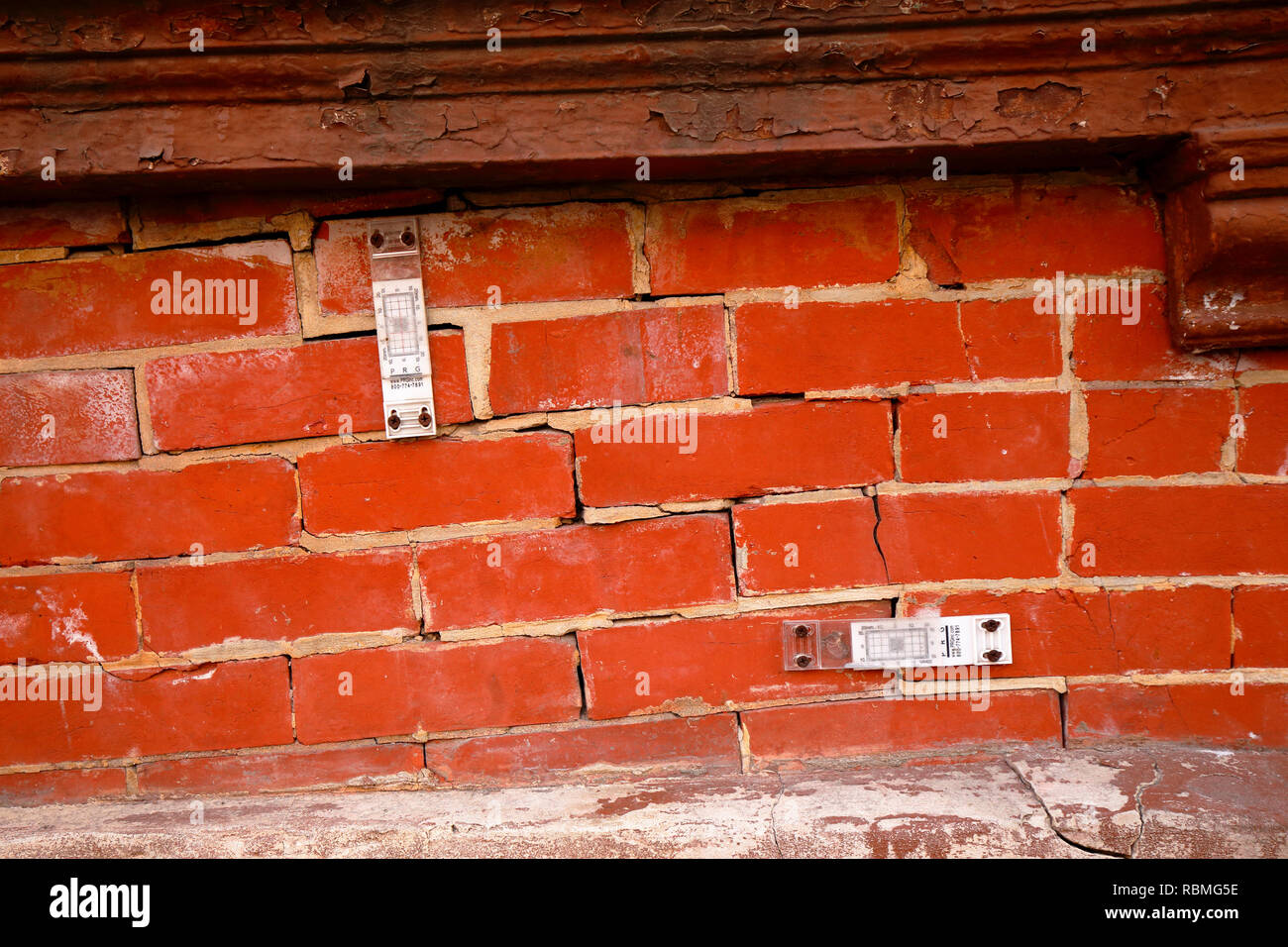 Une paire de jauges de fissures surveille la taille des fissures dans un mur de briques Banque D'Images