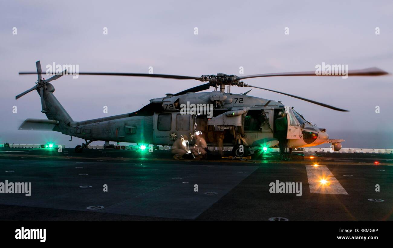 La mer d'OMAN - Marines des États-Unis avec Lima Company, bataillon de l'équipe d'atterrissage 3/1, 13e Marine Expeditionary Unit (MEU), préparer une corde rapide d'un MH-60S Seahawk attaché à la "matraques" d'hélicoptères de combat de la mer (HSC) de l'escadron 21, Essex Groupe amphibie (ARG), à bord de la classe Wasp-navire d'assaut amphibie USS Essex (DG 2), le 9 janvier 2019. L'Essex est le navire amiral de la Essex ARG et, avec l'entrepris 13e MEU, est déployé sur le 5e flotte américaine zone d'opérations à l'appui des opérations navales pour assurer la stabilité et la sécurité maritime dans la région Centrale, reliant la Méditerranée un Banque D'Images