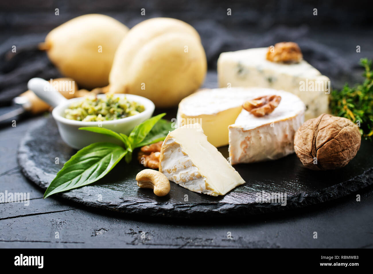 Les écrous avec du fromage et du miel sur planche de bois Banque D'Images