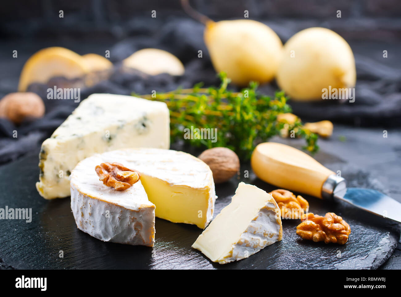 Les écrous avec du fromage et du miel sur planche de bois Banque D'Images