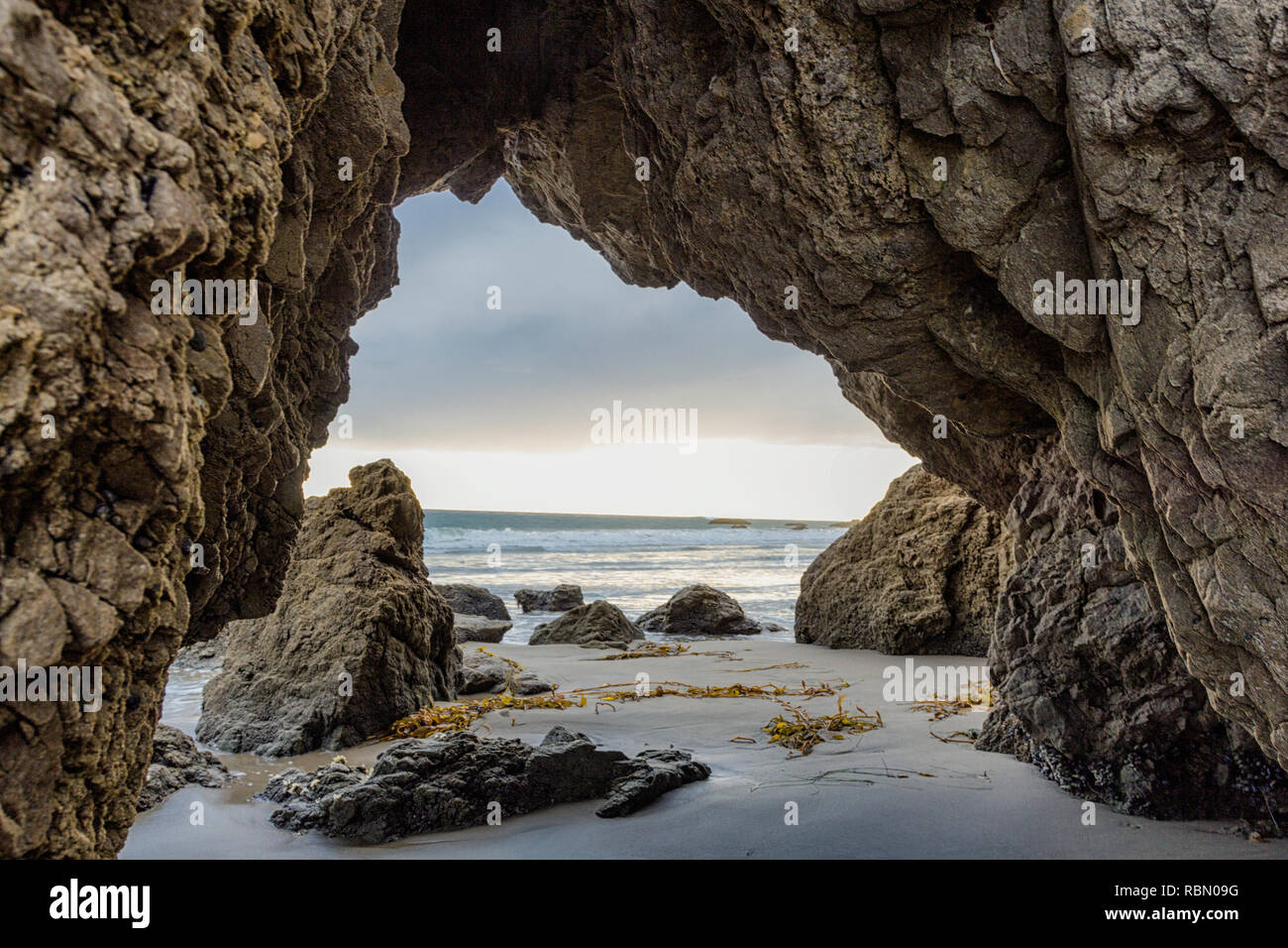 Vue du coucher de soleil par arche naturelle à la plage de Malibu en Californie Banque D'Images