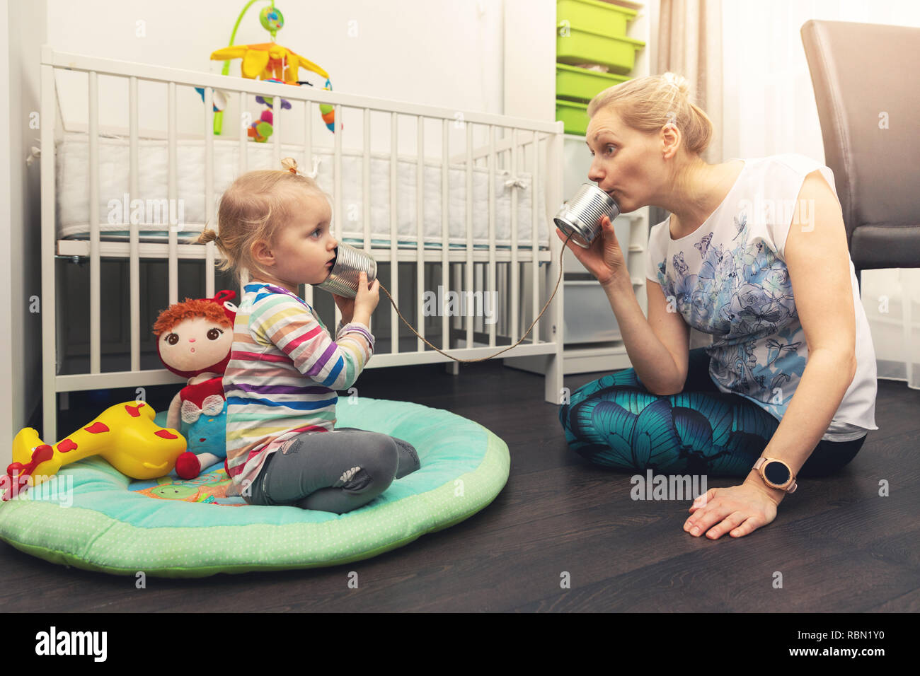 Mère et fille jouer avec de l'étain peut téléphone. parent et enfant communication concept Banque D'Images