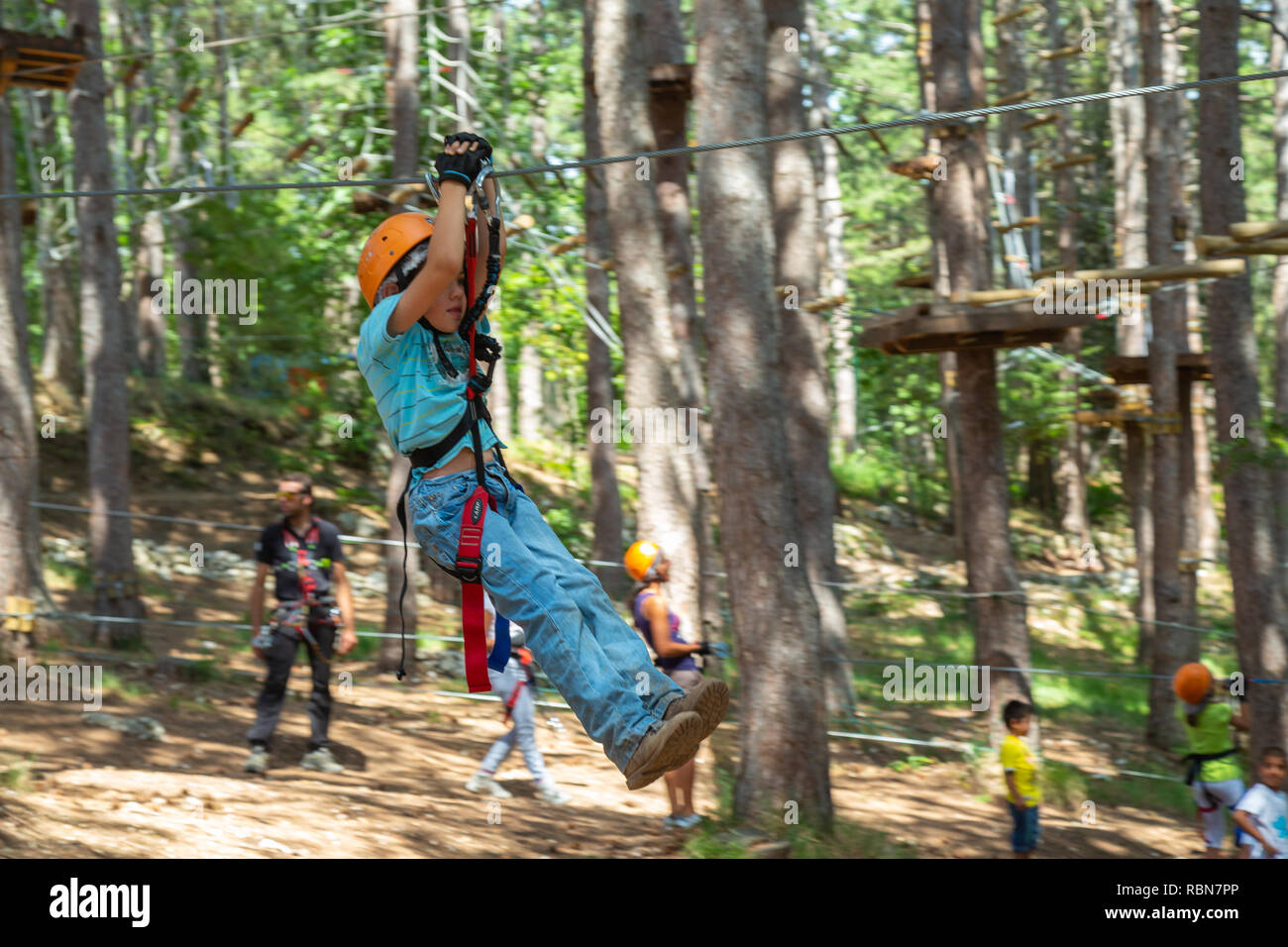 Garçon avec des harnais de sécurité en escalade parc aventure dans la forêt de pins. Guardiagrele, .Abruzzo, Italie Banque D'Images