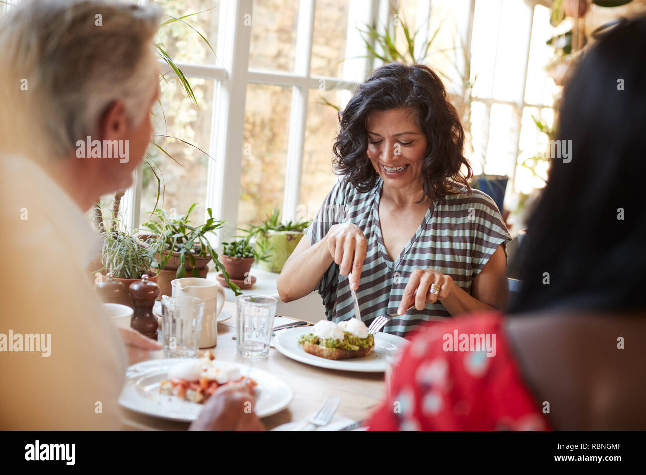 Femme adulte blanc manger avec des amis dans un café, Close up Banque D'Images