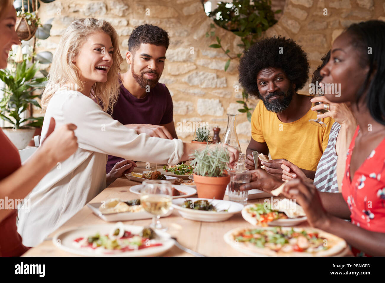 Amis adultes de manger le déjeuner à une table dans un restaurant. Banque D'Images