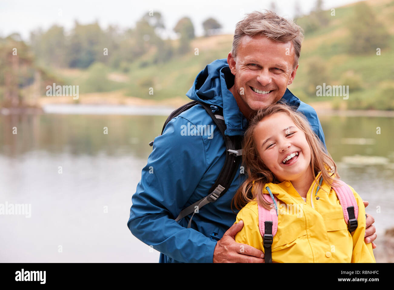 Portrait of pre-teen girl debout avec son père sur la rive d'un lac, riant de caméra, Close up Banque D'Images Portrait of pre-teen girl debout avec son père sur la rive d'un lac, riant de caméra, Close up Banque D'Images