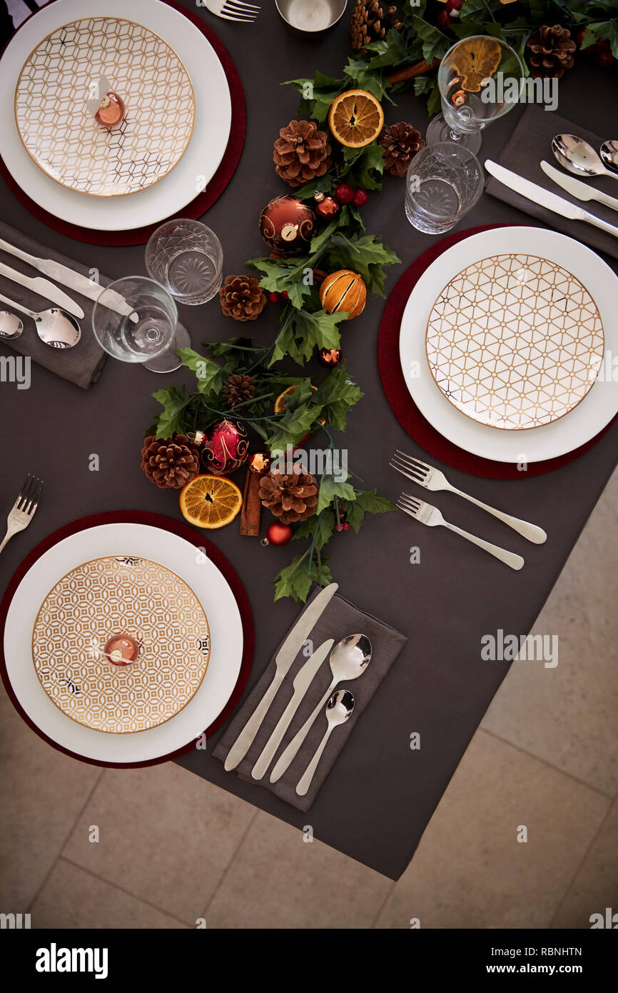 Réglage de la table de Noël babioles avec disposés sur les assiettes et les décorations de table vert et rouge, vue aérienne, verticale Banque D'Images Réglage de la table de Noël babioles avec disposés sur les assiettes et les décorations de table vert et rouge, vue aérienne, verticale Banque D'Images