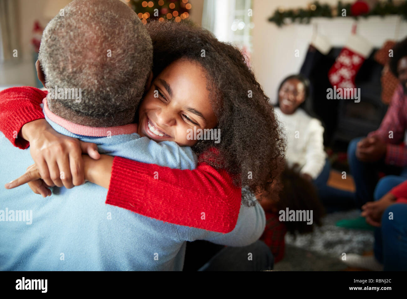 Petite-fille de donner grand-père Hug aussi une génération de la famille célébrer Noël à la maison Banque D'Images