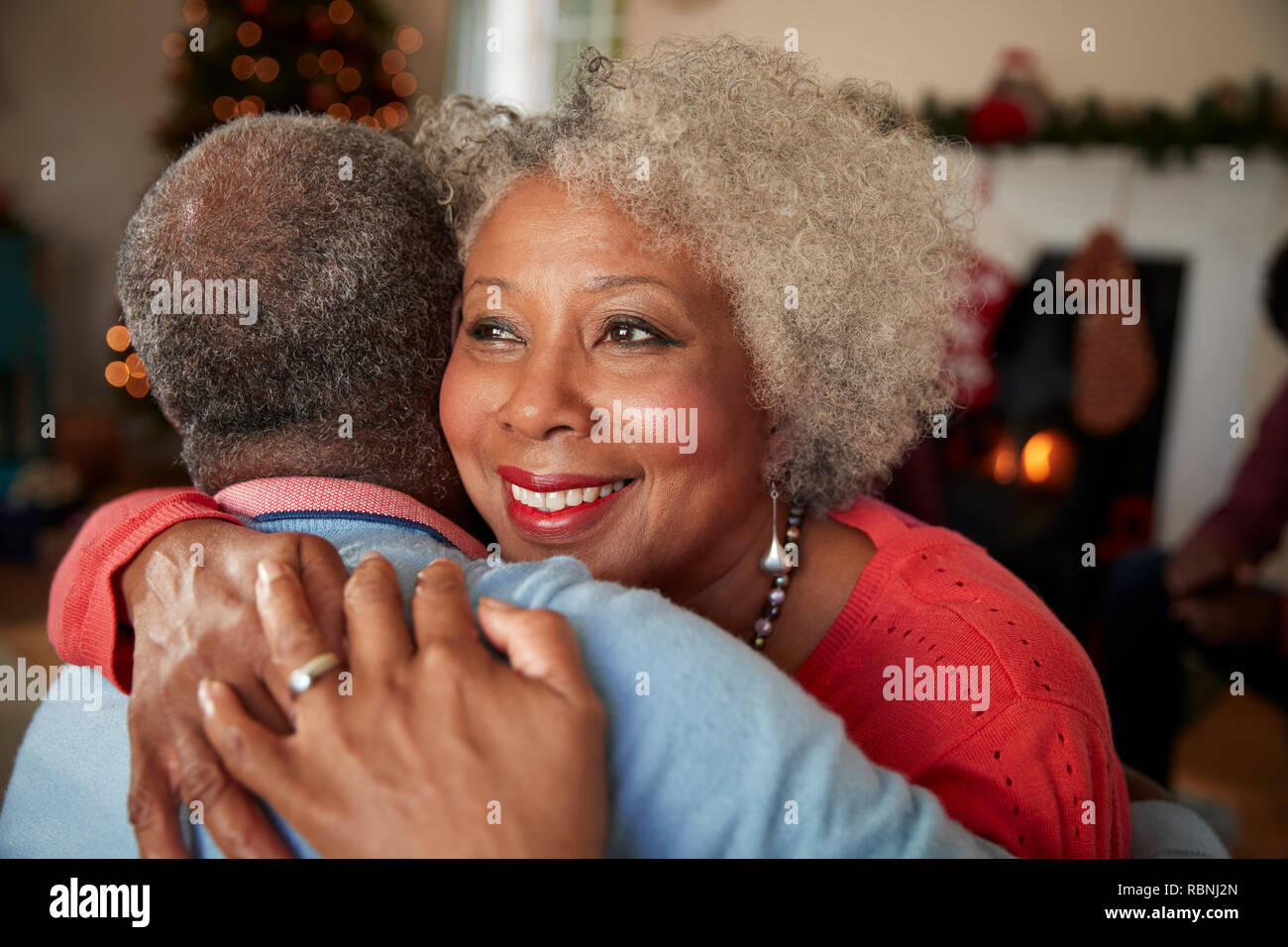 Senior Couple Hugging comme ils célébrer Noël ensemble, à la maison Banque D'Images