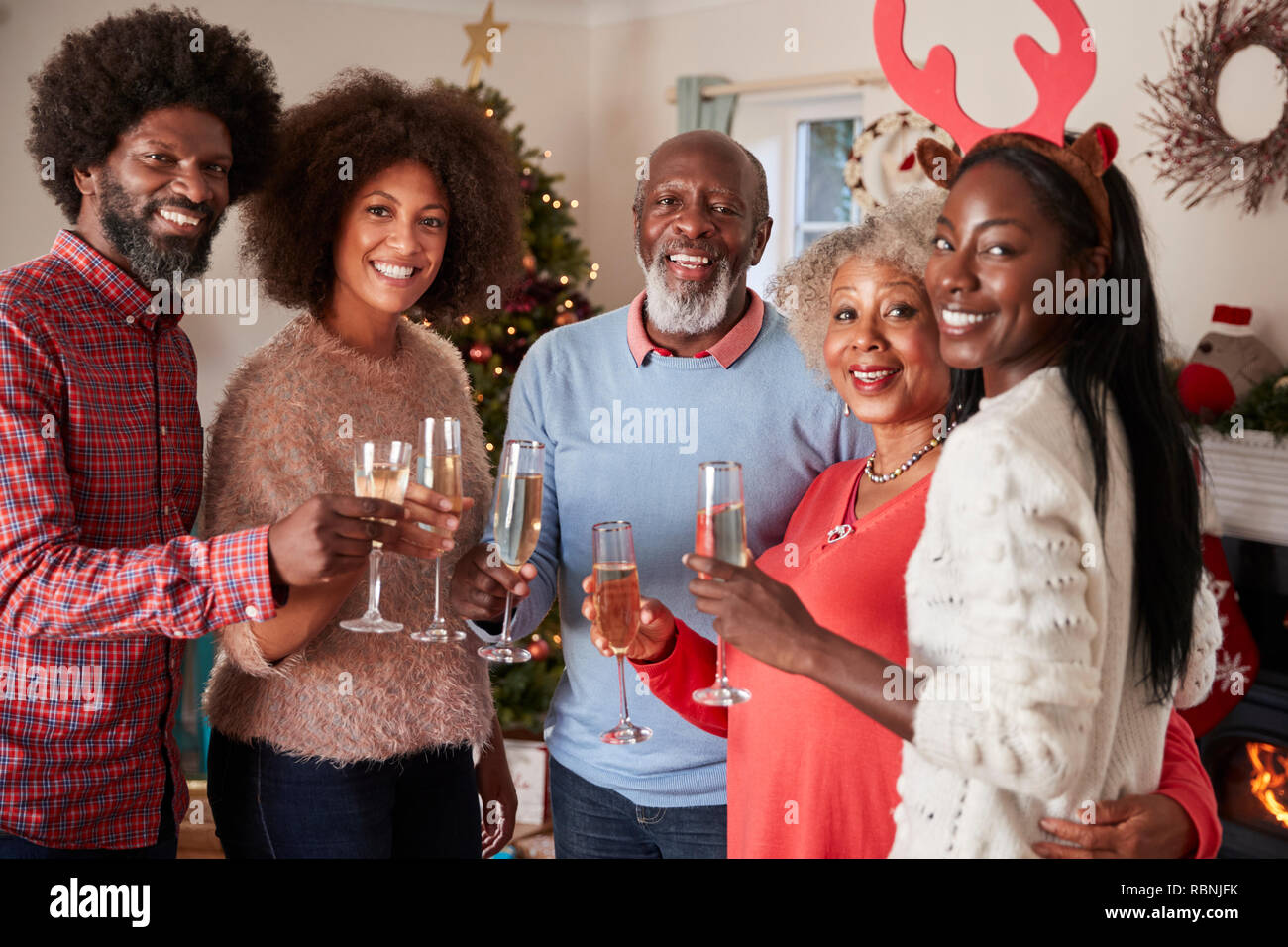 Portrait de parents avec un enfant adulte de faire un toast au champagne pour célébrer Noël ensemble Banque D'Images