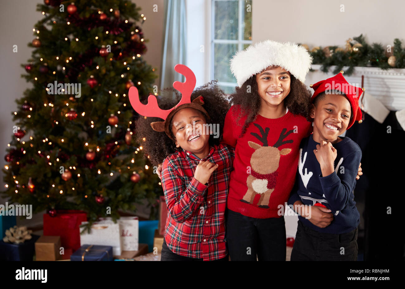 Portrait d'enfants portant des chapeaux de fête des cavaliers et célébrer Noël ensemble, à la maison Banque D'Images